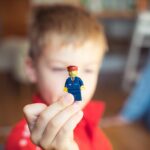 a little boy holding a tiny toy in his hand